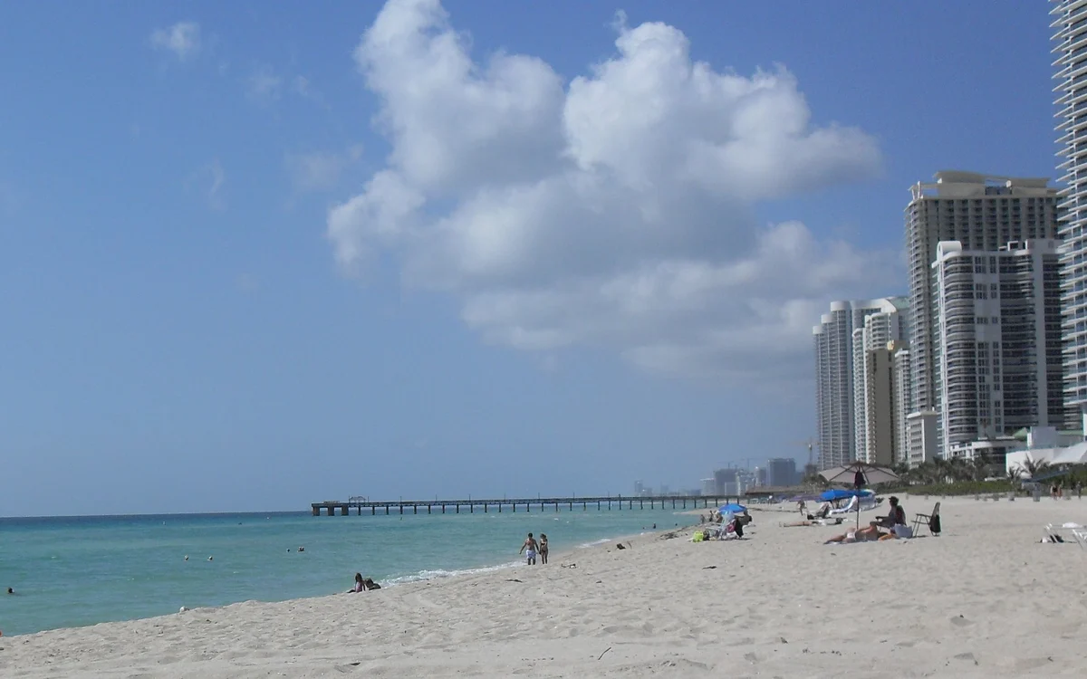 The sand and the fishing pier at Sunny Isles Beach, with the city’s oceanfront condominium towers behind, Miami-Dade County, Florida