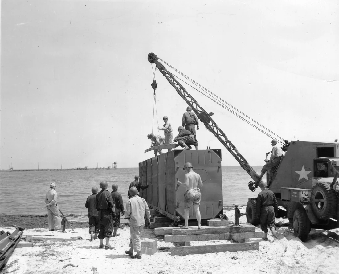 Army engineers at Camp Gordon Johnston build a floating dock from Navy pontoons in May 1944.