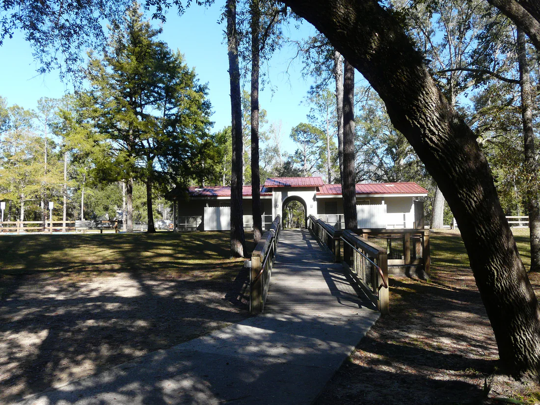The bathroom building at Ponce de Leon Springs State Park, seen past a footbridge.