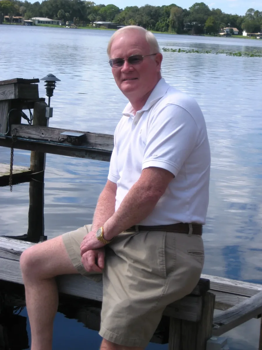 Pat Kiehl of Investors Mortgage LLC, seated on a wooden dock beside a lake